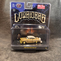 M2 Collectibles Lowriders 1956 Chevrolet Bel Air diecast model car in its original blister packaging, featuring a gold wood-paneled car with a cream top, miniature figures, and a blue Lowriders cardback.