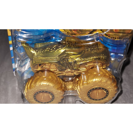 A gold monster truck toy in its original blister packaging, featuring a metallic gold body and oversized gold wheels.