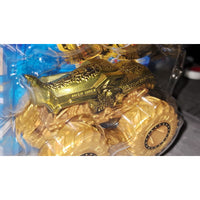 A gold monster truck toy inside clear blister packaging, with the words 'MEGA WARRIOR' visible on the side.